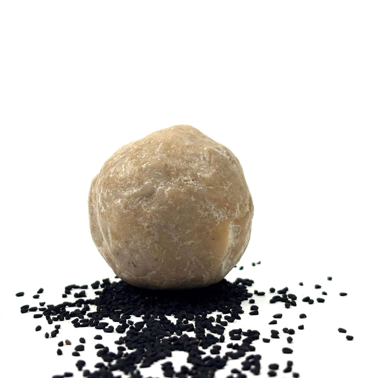 Schwarzkümmel-Seife ca. 120 Gr. auf schwarzem Kümmelsamen Hintergrund.